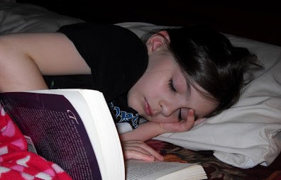 kid falls asleep reading a book at night