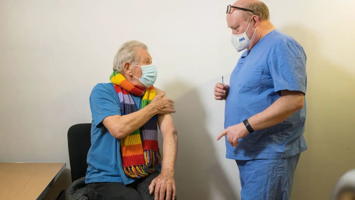 Ian McKellen and the doctor giving him the COVID-19 vaccine